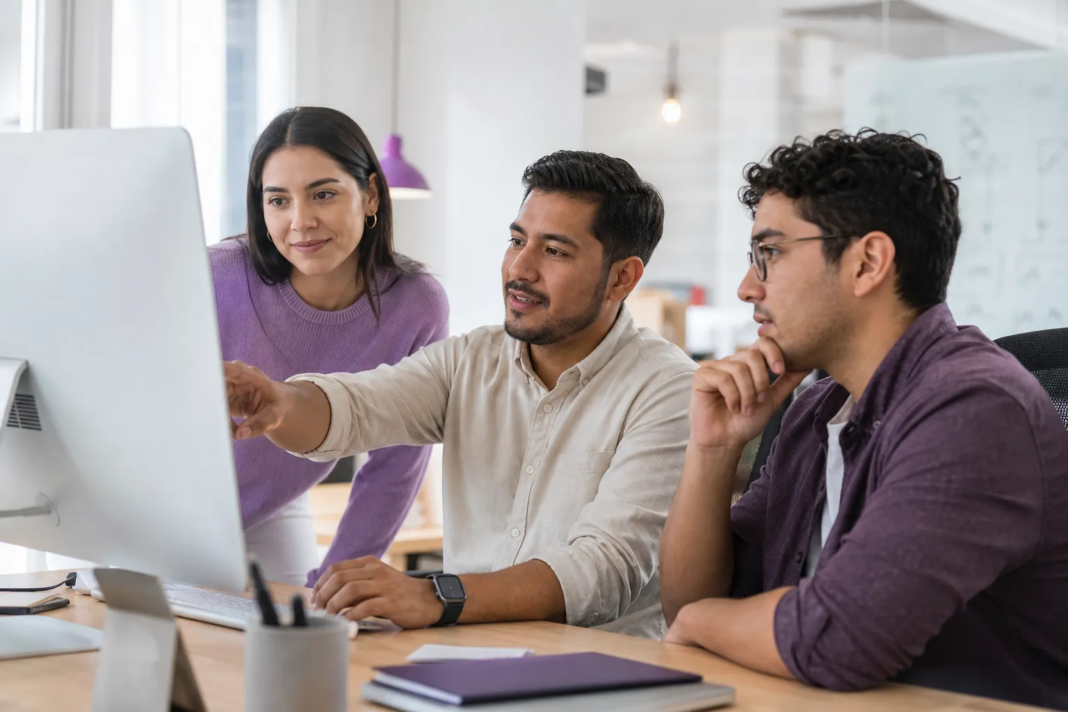 Equipo de profesionales analizando una solución tecnológica frente a un computador